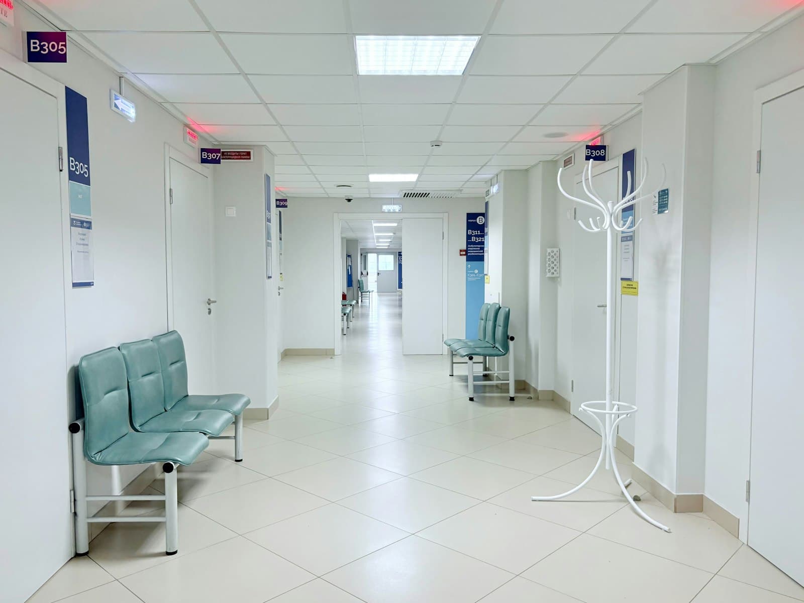 מסדרון ריק ומואר בבית חולים, עם ספסלי המתנה לאורך הקירות